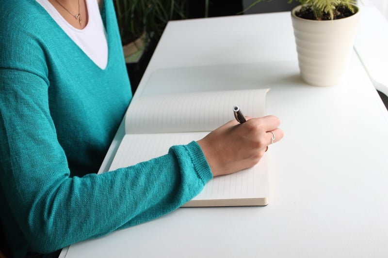 Person writing on a notebook